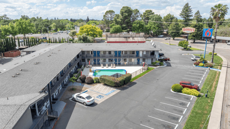 Exterior view of Motel 6 Chico with parking and pool area.