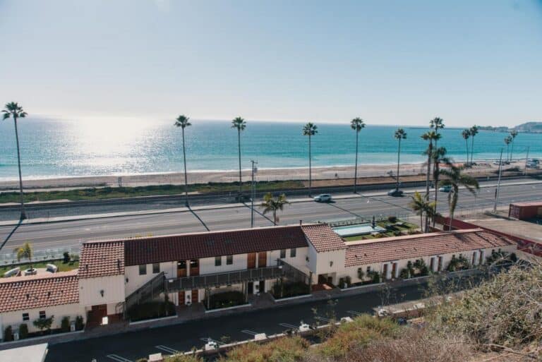 Oceanfront hotel with scenic views of the beach and palm-lined promenade.